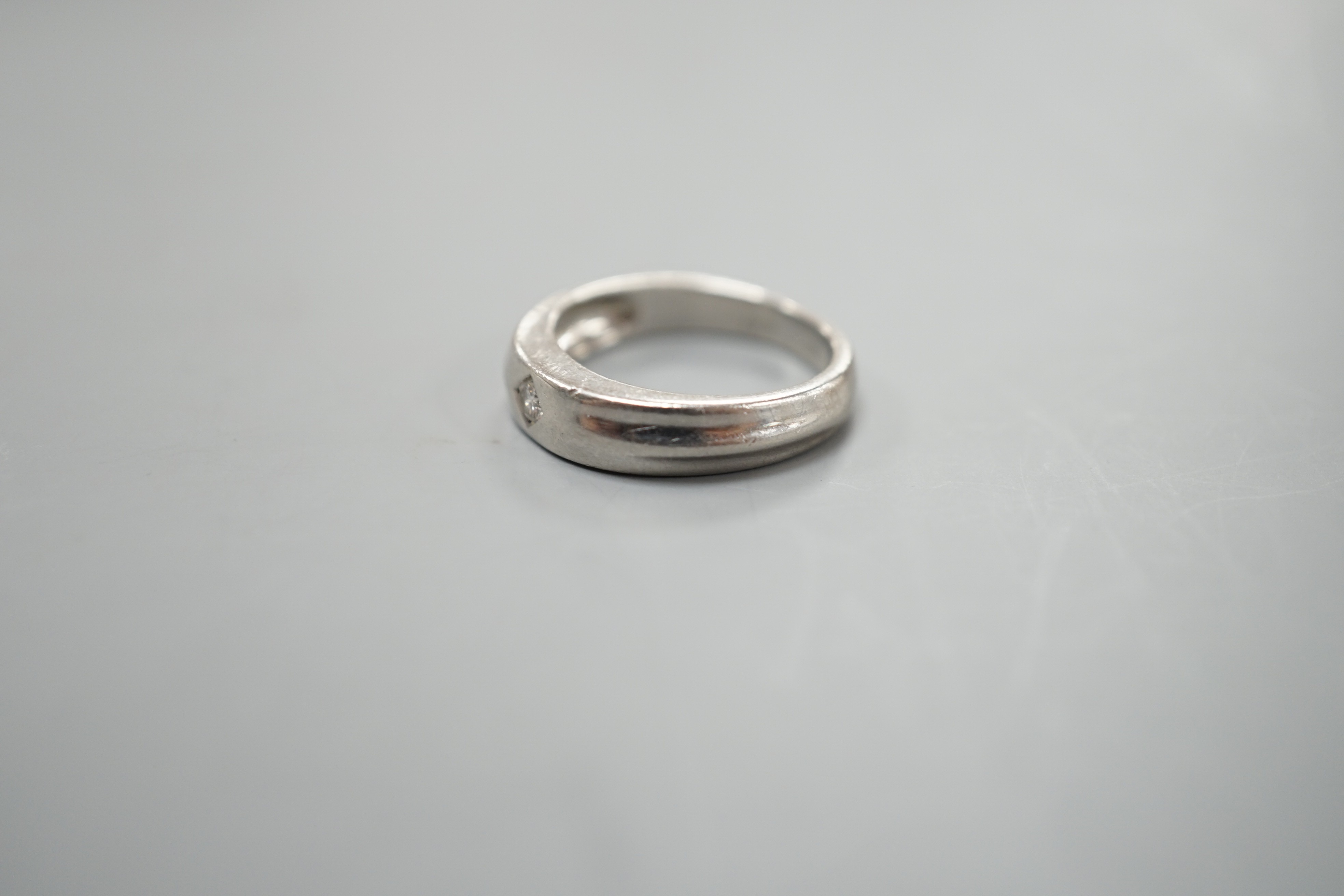 A modern platinum and gypsy set solitaire diamond ring, size K, 6.6 grams.
